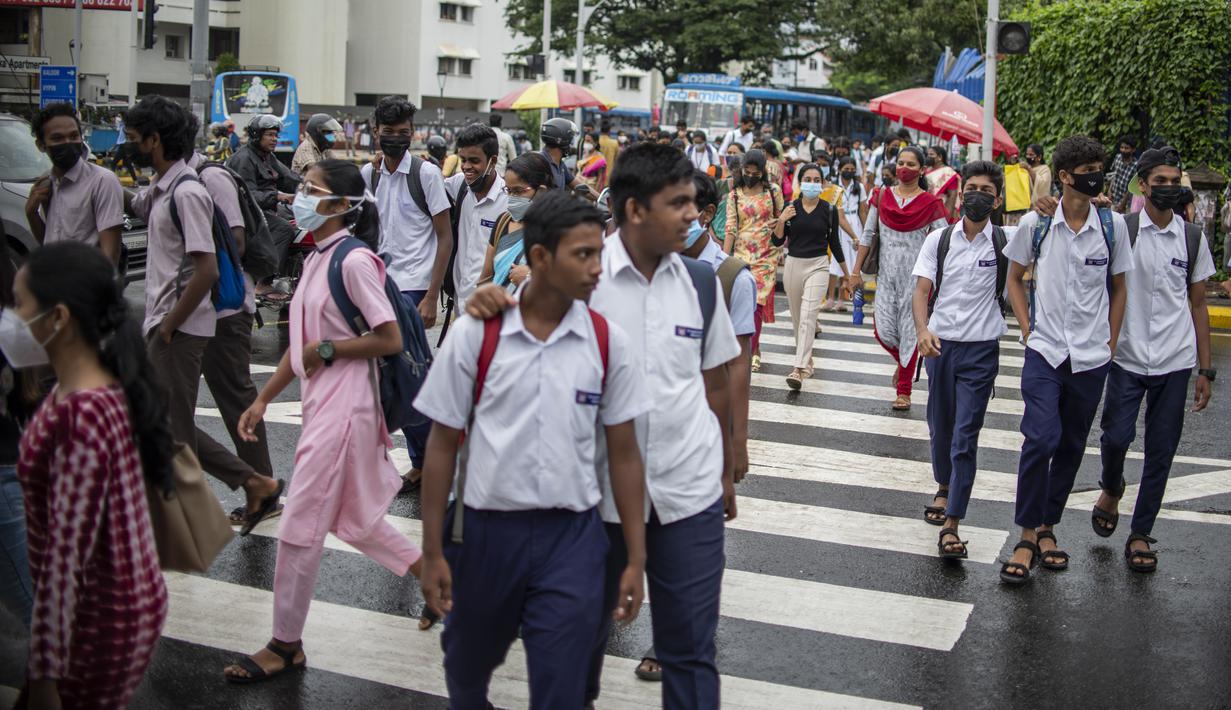 Pejalan kaki yang mengenakan masker berjalan melalui zebra cross di Kochi, negara bagian Kerala, India, Rabu (6/7/2022). Negara bagian selatan itu telah mewajibkan penggunaan masker di tempat-tempat umum menyusul meningkatnya kasus COVID-19. (AP Photo/ RS Iyer)