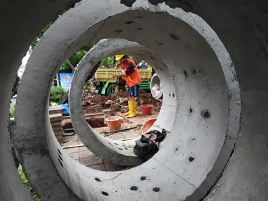 Pekerja saat membuat lubang untuk sumur rasapan di Jalan Kebon Jeruk, Jakarta Barat, Jumat (15/10/2021). Pemda DKI Jakarta menargetkan pembuatan 22.292 titik sumur resapan atau drainase vertikal sebelum memasuki puncak musim penghujan pada awal Januari.  (Liputan6.com/Johan Tallo)