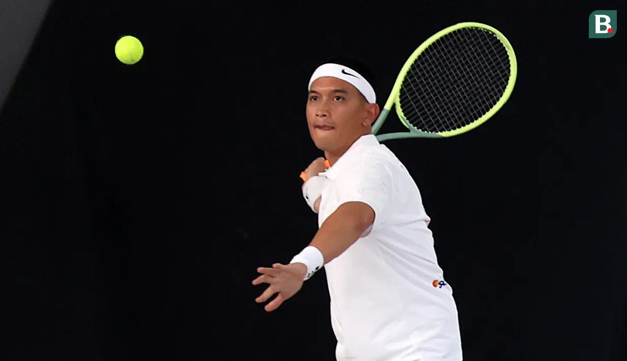 <p>Rezky Aditya berusaha mengembalikan bola dalam pertandingan tenis tunggal putra Turnamen Olahraga Selebriti Indonesia melawan Randy Pangalila yang berlangsung di Gelanggang Olahraga UNJ, Rawamangun, Jakarta Timur, Sabtu (29/7/2023). (Bola.com/Abdul Aziz)</p>