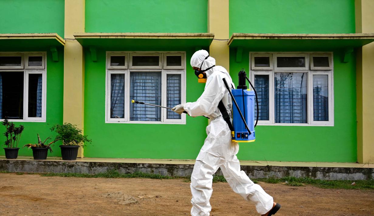 Seorang anggota Badan Penanggulangan Bencana Daerah (BPBD) menyiapkan disinfektan untuk disemprotkan di sebuah Sekolah Menengah Pertama (SMP) dalam rangka program mitigasi pencegahan penyebaran flu burung di Banda Aceh pada Jumat 31 Oktober 2025. Menurut Sukmawati, ini murni langkah pencegahan, bukan karena ada kasus. (Chaideer MAHYUDDIN/AFP)