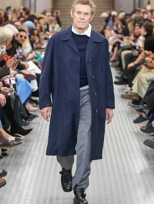 Terakhir, ada aktor berusia 69 tahun Willem Dafoe yang menutup pertunjukan dengan tampilan oh-so-Miuccia yang terdiri dari kemeja di bawah sweater, dilapisi dengan parit biru tua dan celana panjang abu-abu!
