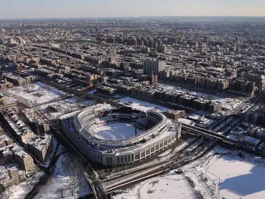 Stadion Yankee dan sekelilingnya memutih diselimuti salju di  Bronx Borough, New York City, Amerika Serikat,  (5/1). Cuaca ekstrem dan terpaan Topan Bom membuat wilayah AS diselimuti salju cukup tebal. (John Moore/AFP)