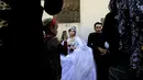 Pasangan pengantin Heba (kanan) dan Ahmed (kiri) saat melakukan prosesi pernikahan di Raqqa, Suriah (27/10). Usai Kota Raqqa diduduki ISIS, pasangan pengantin ini merupakan yang pertama menggelar pernikahan. (AFP Photo/Delil Souleiman)