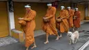 Para biksu Buddha memakai pelindung wajah untuk melindungi diri dari virus corona COVID-19 saat mengumpulkan sedekah di Bangkok, Thailand, Selasa (31/3/2020). Hingga 30 Maret 2020 sore, jumlah kasus COVID-19 di Thailand sebanyak 1.524 positif, 229 sembuh, dan 9 meninggal. (AP Photo/Sakchai Lalit)