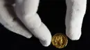 Seorang karyawan Dix Noonan Webb menunjukkan koin Romawi kuno di London, Inggris (28/5/2019). Koin emas ini diperkirakan akan mendapatkan jumlah enam angka ketika itu ditawarkan oleh Dix Noonan Webb dalam lelang dua hari mereka pada bulan Juni. (AP Photo/Kirsty Wigglesworth)