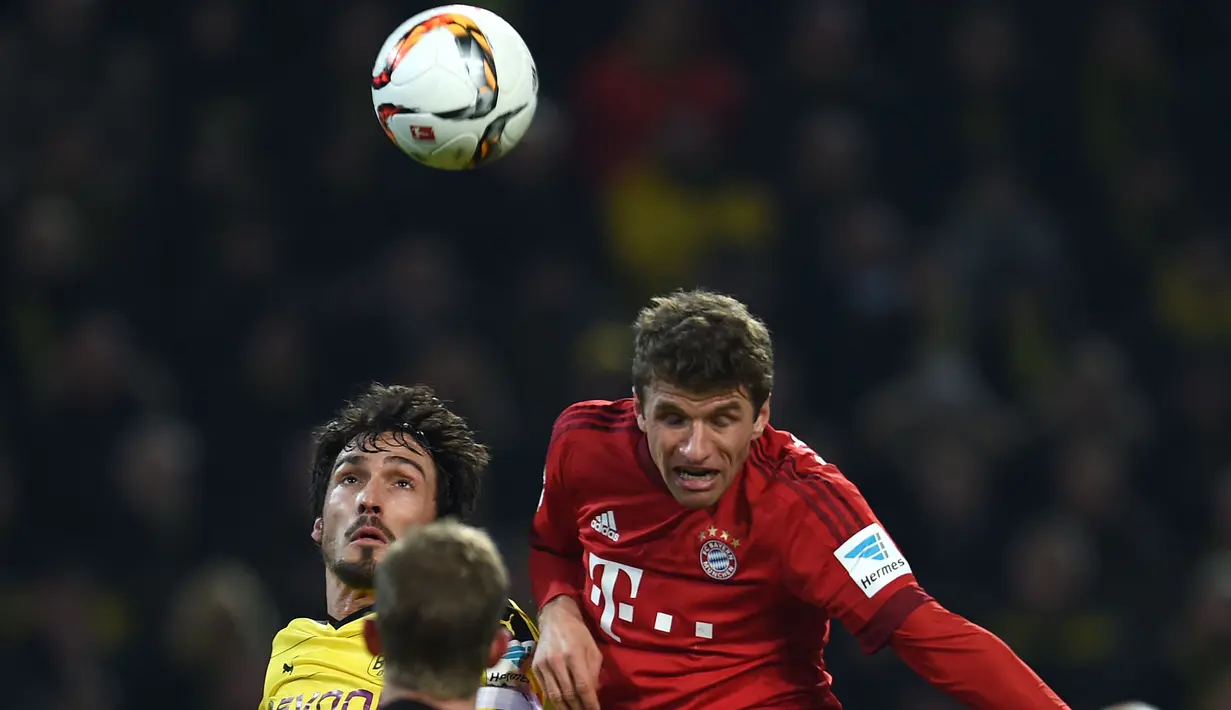 Bayern Munchen, Thomas Mueller (kanan) berduel udara dengan pemain Dortmund, Mats Hummels pada lanjutan Bundesliga 2015-2016 di Stadion Signal Iduna Park ,Dortmund, Minggu (5/3/2016) dini hari WIB. (AFP/Patrik Stollarz) 