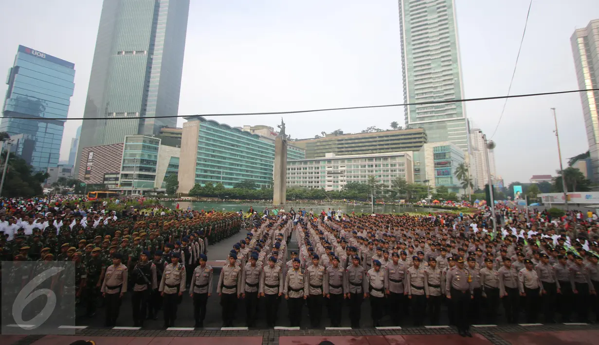 Ratusan personil pengamanan melakukan apel di Bundaran HI, Jakarta, Minggu (1/5). Sebanyak 8.153 petugas dari Polri, TNI, Satpol PP, dan Dinas Perhubungan dikerahkan untuk mengamankan peringatan May Day 2016. (Liputan6.com/Angga Yuniar)