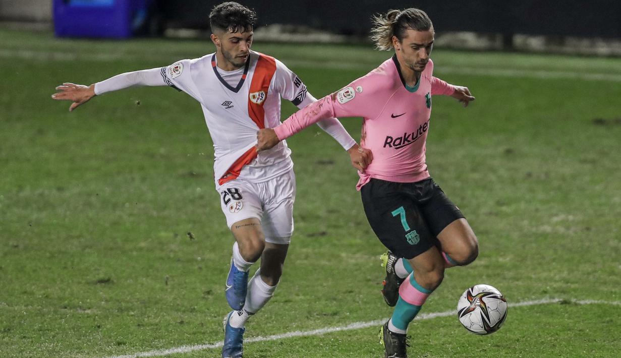 Pemain Rayo Vallecano, Mario Hernandez (kiri) berusaha merebut bola dari pemain Barcelona, Antoine Griezmann pada laga babak 16 Besar Copa del Rey di Vallecas stadium, Madrid, Kamis (28/1/2021). (Foto: AP/Manu Fernandez)
