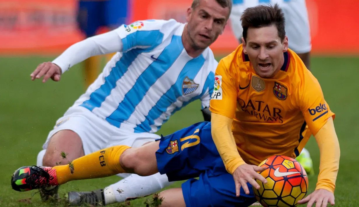 Pemain Barcelona, Lionel Messi (kanan), dijatuhkan pemain Malaga, Duda, dalam laga La Liga Spanyol di Stadion La Rosaleda, Malaga, Sabtu (23/1/2016). (AFP/Jorge Guerrero)