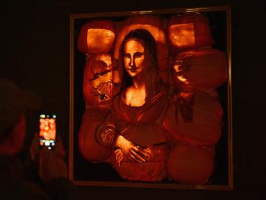 Sebuah labu yang diukir dengan bentuk lukisan Mona Lisa dipajang selama "The Great Jack O'Lantern Blaze" di Croton-on-Hudson, New York menjelang Halloween pada 25 Oktober 2023. (ANGELA WEISS / AFP)