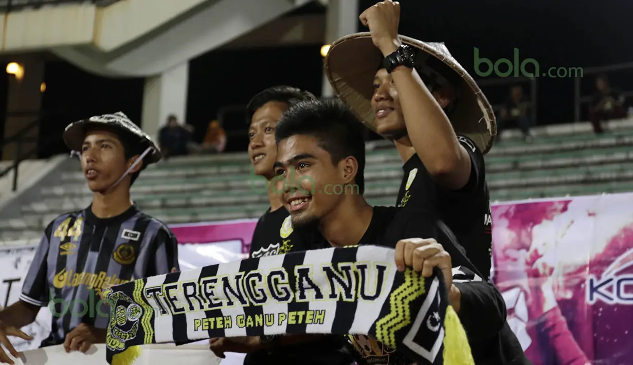 Suporter (Penyokong) mengenakan  atribut khas Terengganu memberi dukungan kepada T-Team saat berlaga pada babak play-off melawan ATM FA di Stadion Perak, Malaysia, Sabtu (30/01/2016). (Bola.com/Nicklas Hanoatubun)