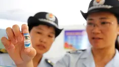 Petugas BPOM China memeriksa vaksin rabies di Pusat Pengendalian dan Pencegahan Penyakit di Huaibei, provinsi Anhui, Selasa (24/7). Otoritas China menginvestigasi skandal produksi vaksin rabies ilegal yang telah menimbulkan kepanikan masyarakat. (AFP)