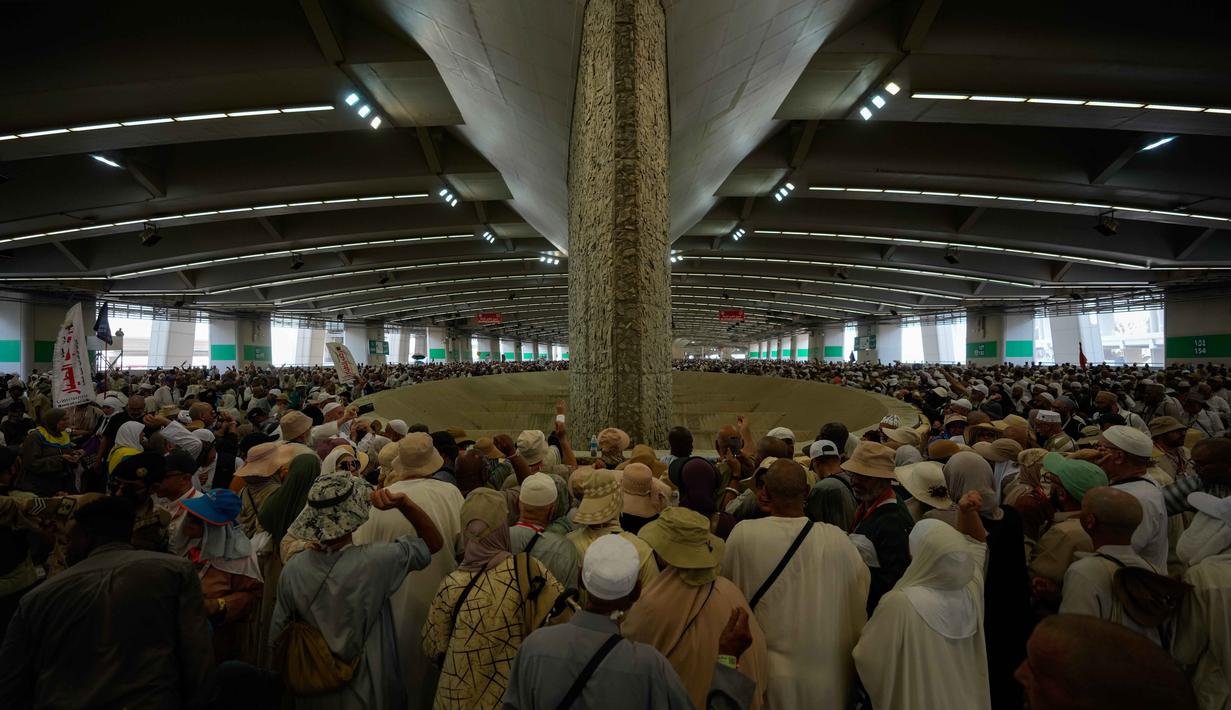 Jemaah Muslim melemparkan kerikil ke tiang-tiang sebagai simbol pelemparan batu ke setan pada hari kedua ritual, salah satu upacara terakhir ibadah haji tahunan, di Mina, Arab Saudi, Kamis 28 Mei 2026. (AP Photo/Altaf Qadri)