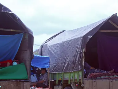 Pengungsi Gunung Agung beraktivitas di atas truk yang terparkir di Klungkung, Bali, Sabtu (23/9). Sebagian pengungsi memilih tinggal sementara dan menyimpan barang bawaan di atas truk karena merasa lebih nyaman. (AP Photo/Firdia Lisnawati)