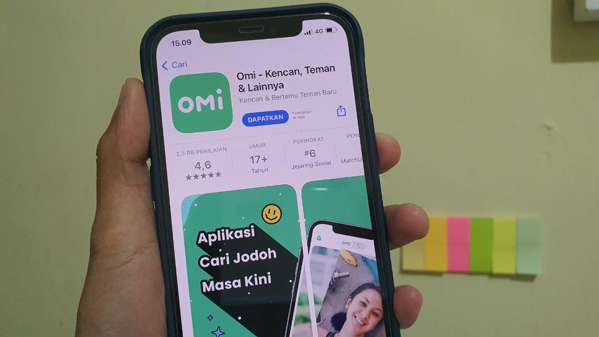  A hand holding a phone with the Omi app open. The app is a dating app that allows users to search for potential matches based on their location, age, and interests.