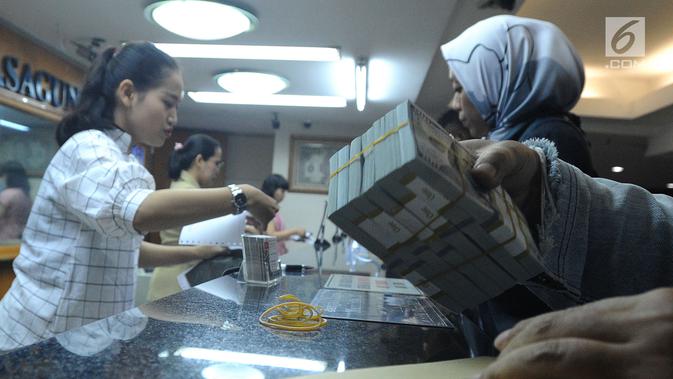 Petugas melayani nasabah di gerai penukaran mata uang di Ayu Masagung, Jakarta, Senin (13/8). Pada perdagangan jadwal pekan, senin (13/08). Nilai tukar rupiah terhadap dolar AS menyentuh posisi tertingginya Rp 14.600. (Merdeka.com/Arie Basuki)