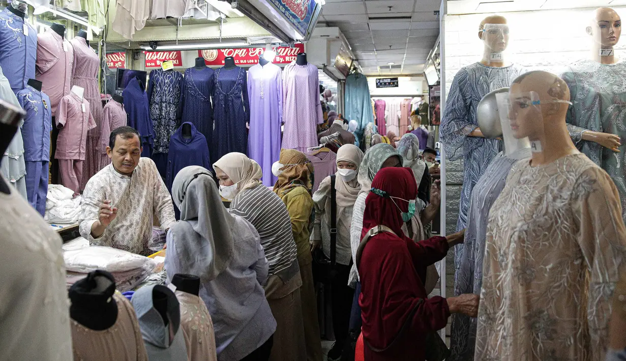 Pedagang melayani pembeli perlengkapan ibadah di Pasar Tanah Abang Blok A, Jakarta, Senin (4/4/2022). Penjualan busana muslim seperti mukena, kerudung, sajadah dan sarung mengalami peningkatan di bulan Ramadhan. (Liputan6.com/Faizal Fanani)