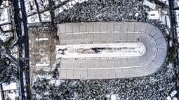 Stadion Panathenian, tempat Olimpiade modern pertama diadakan pada tahun 1896, tertutup salju setelah hujan salju lebat di Athena, Yunani, Rabu (17/2/2021). Salju adalah pemandangan langka di ibu kota Yunani ini. (Antonis Nikolopoulos/Eurokinissi via AP)