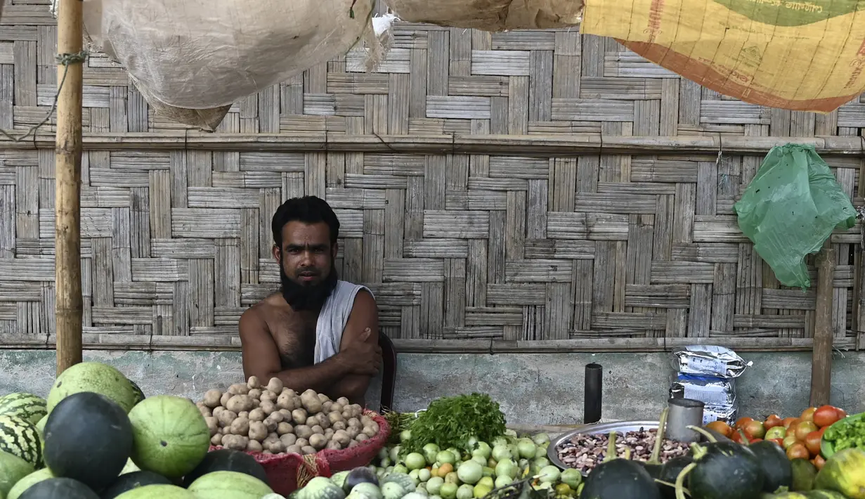 Pengungsi Rohingya menjual buah dan sayuran di kiosnya di kamp pengungsi Jamtoli di Ukhia (22/3/2022). Ratusan ribu orang Rohingya melarikan diri dari Myanmar setelah tindakan keras tahun 2017, yang menjadi subjek kasus genosida di pengadilan tertinggi PBB di Den Haag. (AFP/Munir Uz Zaman)