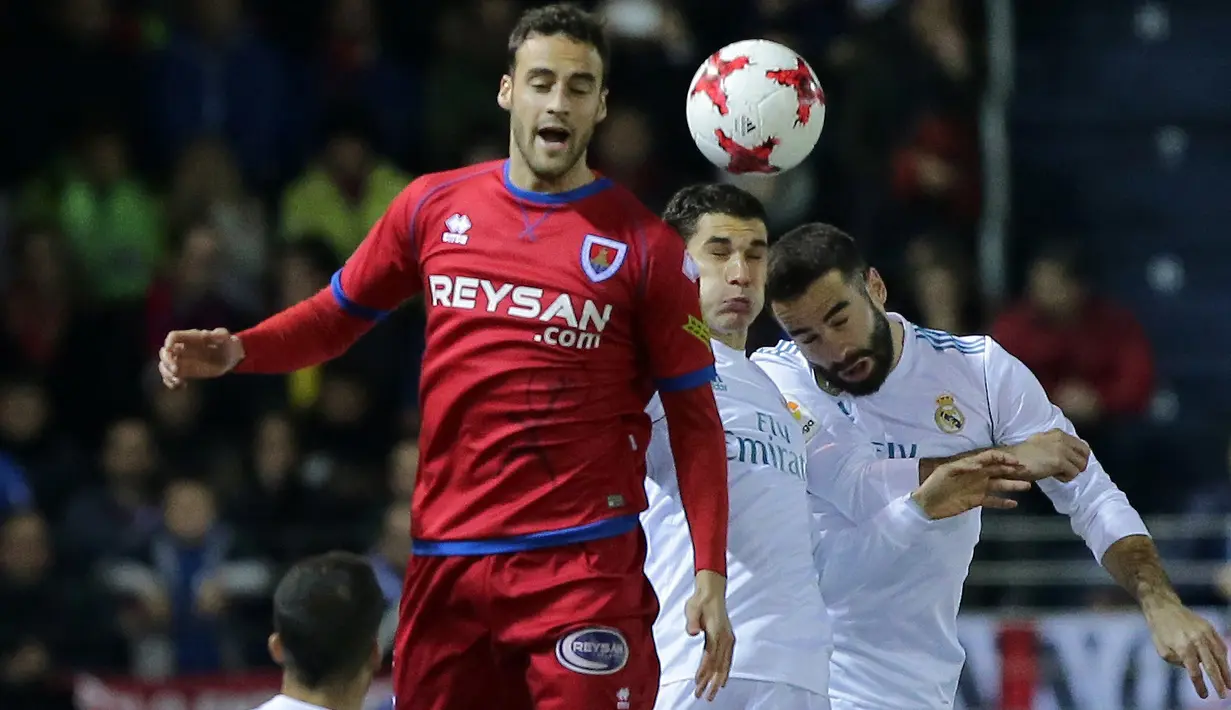 Duel pemain Numancia, Pere Milla (kiri) dengan pemain Real Madrid pada laga Copa Del Rey di Nuevo Estadio Los Pajaritos stadium, Soria, (4/1/2018). Madrid menang 3-0. (AFP/Cesar Manso)