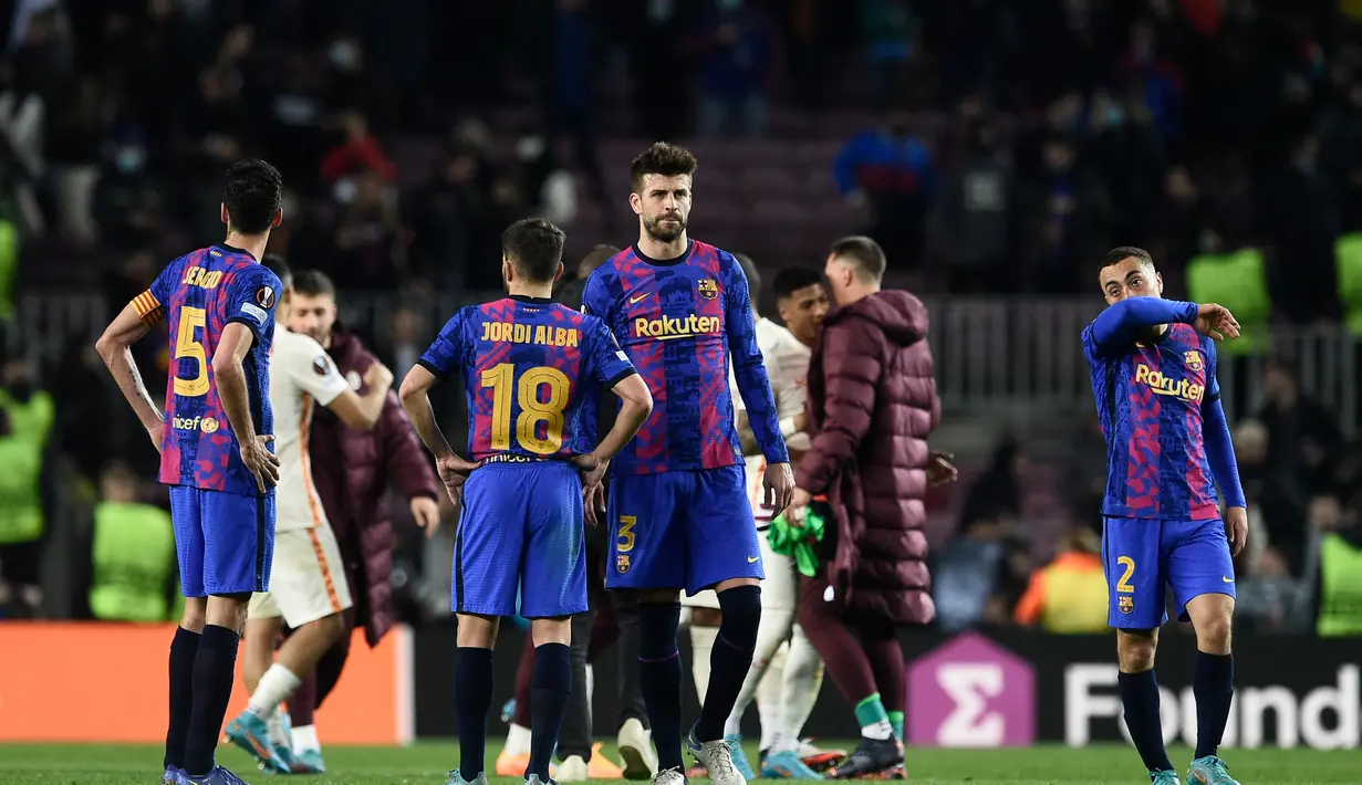 Bek Barcelona Spanyol Gerard Pique (tengah) dan rekan satu timnya bereaksi usai pertandingan melawan Galatasaray pada pertandingan leg pertama babak 16 besar Liga Europa di stadion Camp Nou di Barcelona (11/3/2022). Barcelona bermain imbang atas Galatasaray 0-0. (AFP/Lluis Gene)