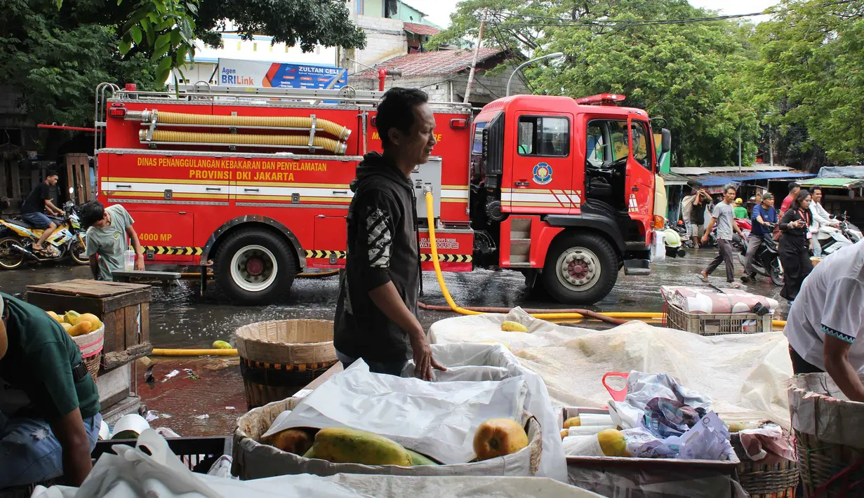 Sebelumnya, Suku Dinas Penanggulangan Kebakaran dan Penyelamatan Jakarta Timur menerima laporan kebakaran pukul 07.24 WIB dari seorang warga. Tampak dalam foto, beberapa pedagang berupaya menyelamatkan sisa dagangannya setelah api yang membakar Pasar Induk Kramat Jati Jakarta berhasil dipadamkan pada Senin (15/12/2025). (merdeka.com/magang/Rendi Saputra)