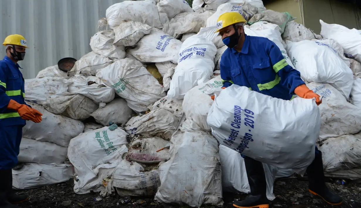 Pekerja dari perusahaan daur ulang memuat sampah yang dikumpulkan dari Gunung Everest di Kathmandu, 5 Juni 2019.  Ekspedisi pemerintah Nepal selama 45 hari mengumpulkan pembungkus makanan, kaleng, botol, tabung oksigen kosong dan limbah lainnya dari gunung setinggi 8.850 meter. (PRAKASH MATHEMA/AFP)