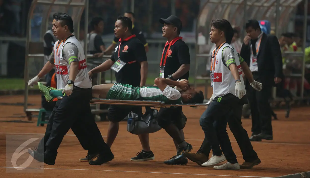 Pemain PS TNI ditandu keluar lapangan akibat cedera saat laga melawan Persija di lanjutan Torabika Soccer Championship presented by IM3 Ooredoo di Stadion GBK Jakarta, Jumat (10/6). Persija unggul 1-0. (Liputan6.com/Helmi Fithriansyah)