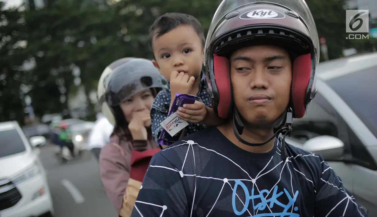 Seorang anak menerima cokelat dari Relawan yang tergabung dalam Kita Satu Relawan Millennial Jokowi-Amin di kawasan Patung Kuda, Jakarta, Kamis (18/4). Kegiatan tersebut sebagai bentuk terima kasih kepada seluruh anak bangsa yang telah ikut memberikan suaranya di TPS. (Liputan6.com/Faizal Fanani)