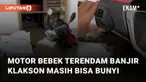 Sebuah sepeda motor yang setengah badannya sudah terendam banjir mengundang perhatian