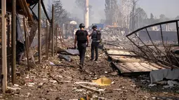 Petugas kepolisian memeriksa lokasi setelah serangan Rusia menghantam sebuah gudang di desa Myla, wilayah Kyiv, Ukraina, pada hari Sabtu, 29 Agustus 2026. (Foto AP/Dan Bashakov)