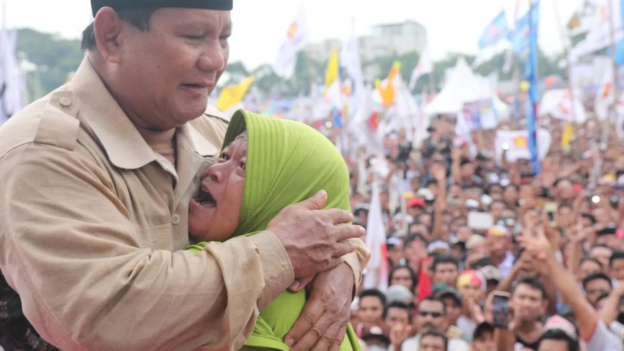 Prabowo Subianto dipeluk seorang emak-emak saat melakukan kampanye di Nusa Tenggara Barat di lapangan Karang Pule, Mataram, Selasa, (26/3/2019).