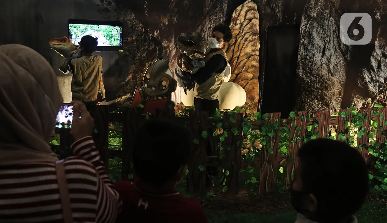 Pengunjung menyaksikan replika hewan prasejarah dalam wahana Dino Factory by Dino Island di Mal Kota Kasablanka, Jakarta, Jumat (17/12/2021). Wahana dihardikan untuk memeriahkan Natal 2021 dan tahun baru 2022. (Liputan6.com/Herman Zakharia)