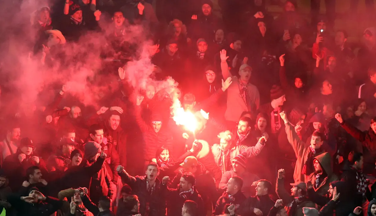 Aksi suporter Nice menyalakan flare saat timnya membobol gawang AS Monaco pada lanjutan Ligue 1 di Louis II Stadium, Monaco, (16/1/2018). AS Monaco bermain imbang 2-2 dengan Nice. (AFP/Valery Hache)