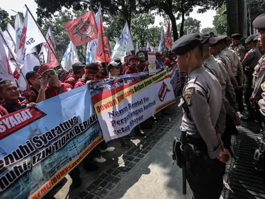 Sejumlah petugas kepolisian berjaga saat aksi unjuk rasa di depan kantor Kementerian BUMN, Jakarta, Senin (31/7). Dalam aksinya mereka  menuntut evaluasi Kementerian BUMN terkait adanya potensi kerugian negara. (Liputan6.com/Faizal Fanani)