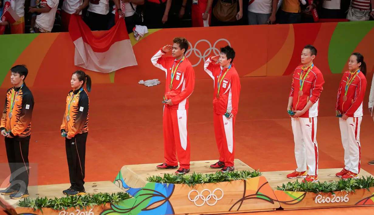 Pasangan ganda campuran Indonesia, Tontowi Ahmad dan Liliyana Natsir berdiri di atas podium saat menyanyikan lagu Indonesia Raya dan meraih medali usai laga final bulutangkis di Riocentro Pavilion 4, Brasil. (REUTERS/Mike Blake)