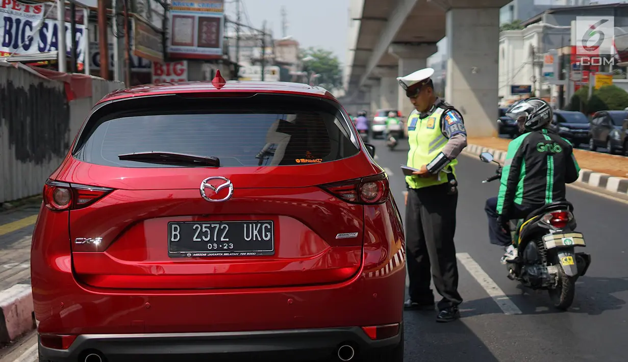 Petugas Kepolisian memberhentikan mobil berplat nomor genap yang memasuki persimpangan Jalan Dharmawangsa X dan Jalan Fatmawati, Jakarta, Senin (9/9/2019). Polisi mulai menindak pengendara yang melanggar perluasan ganjil genap di Jakarta Selatan. (Liputan6.com/Immanuel Antonius)