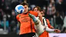 Bek Spezia Salvador Ferrer (kiri) berebut bola dengan bek Juventus Luca Pellegrini (kanan) pada pertandingan Liga Italia pekan ke-28 di Allianz Stadium, Senin (7/3/2022) dini hari WIB. Juventus menang 1-0 atas Spezia lewat gol Alvaro Morata. (MIGUEL MEDINA / AFP)
