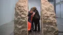 Seniman Perancis, Abraham Poincheval dibantu keluar usai tinggal selama sepekan dari dalam batu berbobot 12 ton, Perancis, Rabu (1/3). Dia melubangi bagian dalam batu sesuai ukuran tubuhnya dalam posisi duduk. (AP Photo/Zacharie Scheurer)