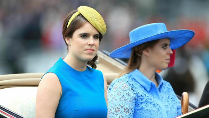 Putri Inggris Eugenie (kiri) dan Putri Beatrice mengenakan topi atau fascinator unik saat menghadiri ajang pacuan kuda Royal Ascot di Ascot, Inggris, Selasa (18/6/2019). Royal Ascot menjadi ajang bagi wanita Inggris untuk tampil dengan fascinator unik. (Mike Egerton/PA via AP)