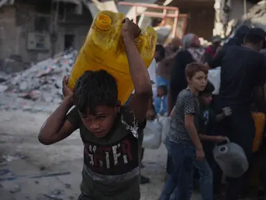 Warga Palestina membawa jerigen berisi air yang mereka kumpulkan dari sebuah truk di Kota Gaza, Kamis 16 Oktober 2025. (AP Photo/Jehad Alshrafi)