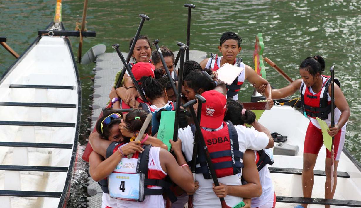 Tim putri Indonesia meluapkan kegembiraan setelah meraih medali emas saat berlomba di nomor 12 Kru 200m Perahu Naga SEA Games 2015 di Marina Bay, Singapura. Sabtu (6/6). (Bola.com/Arief Bagus)