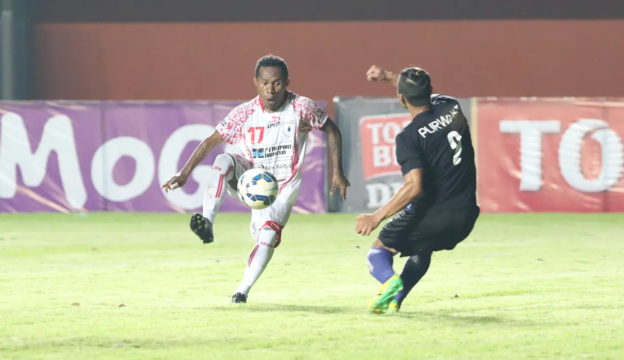 Pemain Persipura Jayapura, Ferinando Pahabol mengecoh pemain Arema Cronus Purwaka pada laga grup E Piala Jenderal Sudirman di Stadion Maguwoharjo, Sleman, Minggu (13/12/2015) (Bola.com/Nicklas Hanoatubun) 