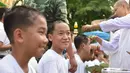 Biksu mencukur rambut anak-anak, yang diselamatkan dari gua di Thailand, pada upacara pentahbisan di Kuil Wat Phra That Doi Wao, Chiang Rai, Selasa (24/7). 11 dari 12 remaja itu menjalani ritual menjadi biksu. (Panumas Sanguanwong/THAI NEWS PIX/AFP)