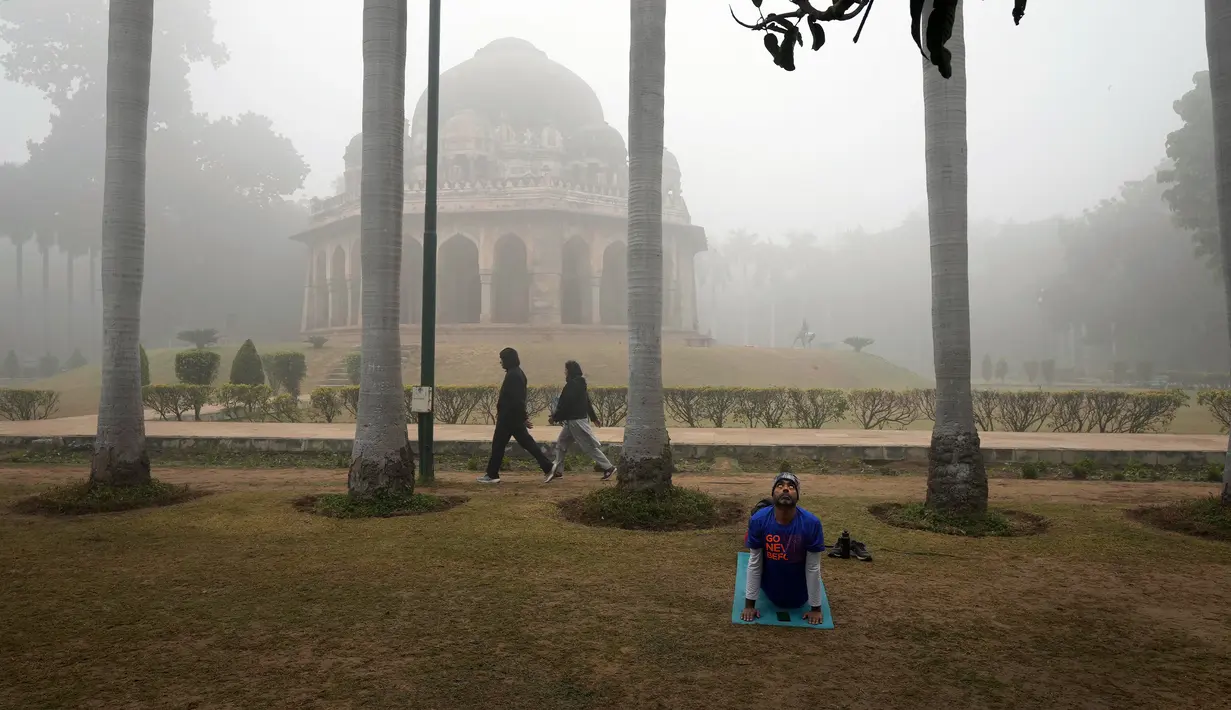 Orang-orang berolahraga di taman saat kabut asap pagi di New Delhi, India, Selasa (20/12/2022). India Utara mengalami kabut pertama musim ini dan diperkirakan akan berlangsung selama lima hari ke depan yang mengganggu transportasi kereta api, jalan raya, dan udara. (AP Photo/Manish Swarup)