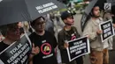 Aktivis Jaringan Solidaritas Korban untuk Keadilan menunjukkan poster tuntutan saat menggelar aksi Kamisan ke-575 di depan Istana Merdeka, Jakarta, Kamis (21/2). Aktivis menolak kembalinya militer untuk menduduki jabatan sipil. (Liputan6.com/FaizalFanani)