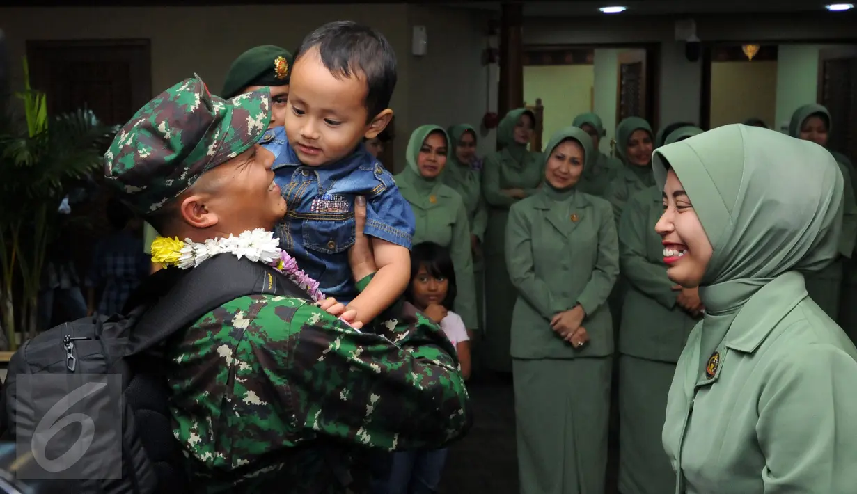 Personel TNI AD yang tergabung dalam kontingen AASAM menggendong sang buah hati saat penyambutan kedatangan di Bandara Soetta, Banten, Senin (23/5/2016). TNI AD menjadi juara umum AASAM 2016 yang digelar di Australia. (Liputan6.com/Helmi Fithriansyah)