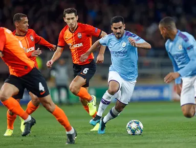 Gelandang Manchester City, Ilkay Gundogan berlari sambil membawa bola menghindari hadangan pemain Shakhtar Donetsk pada laga pertama Grup C Liga Champions di Metalist Stadium, Rabu (18/9/2019). Manchester City sukses menghantam Shakhtar Donetsk dengan skor 3-0. (AP Photo/Efrem Lukatsky)