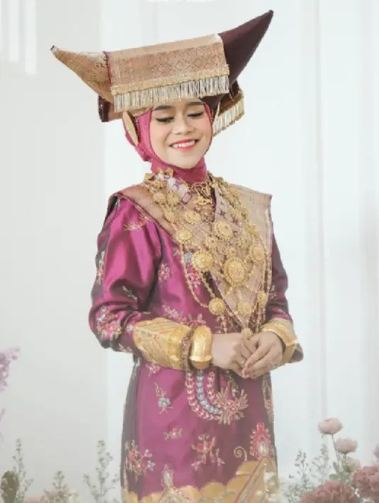 Baju kurung, songket, dan berbagai aksesori dengan nuansa emas melekat di tubuh Lesti Kejora, disempurnakan dengan penutup kepala yang juga khas Minang, dikenal dengan sebutan Tingkuluak. Foto: Instagram @aldiphoto.