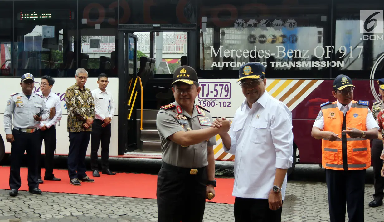 Menteri Perhubungan Budi Karya Sumadi melakukan salam komando dengan Kapolri Jenderal Tito Karnavian saat meresmikan Operasi Green Line dan pelepasan Bus TransJabodetabek Premium di Mega City, Bekasi Barat, Senin  (12/3). (Liputan6.com/Arya Manggala)